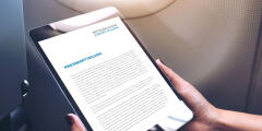 A person holding a tablet with a news page open